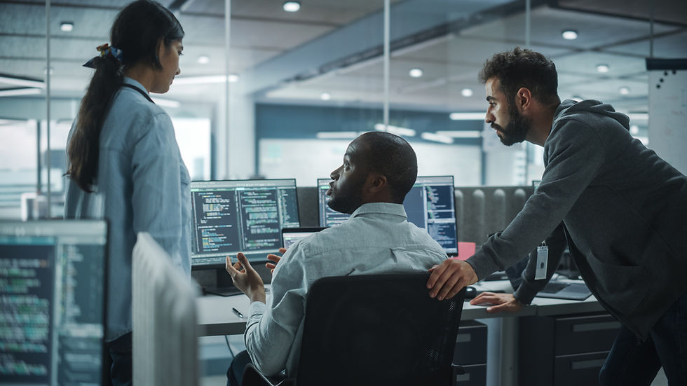 A group of people looking at a computer in an office and discussing