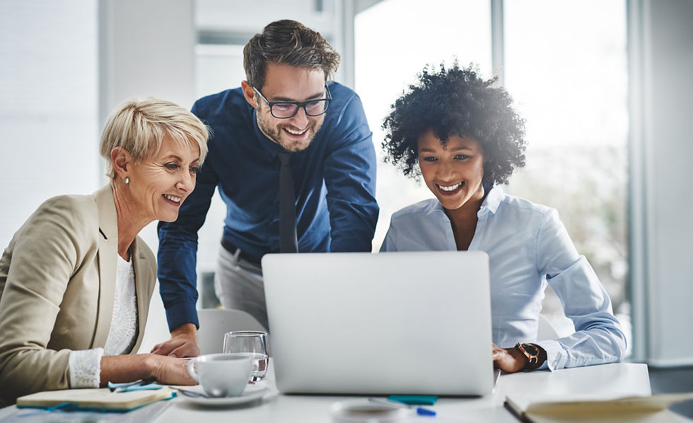 A group of people looking at a laptop in an office
