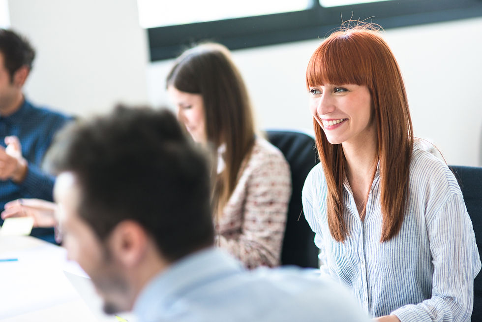 Woman sitting at a conference table smiling